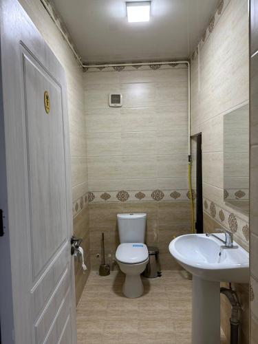 a bathroom with a toilet and a sink at LOONA FAMILY HOSTEL in Tashkent