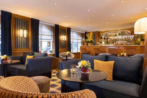 un restaurant avec des chaises et des tables et un bar dans l'établissement Hôtel Horset Opéra, Best Western Premier Collection, à Paris