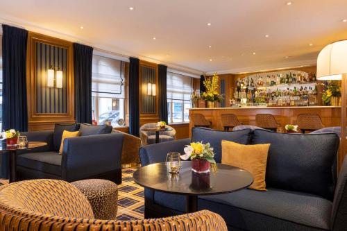 a restaurant with chairs and tables and a bar at Hôtel Horset Opéra, Best Western Premier Collection in Paris