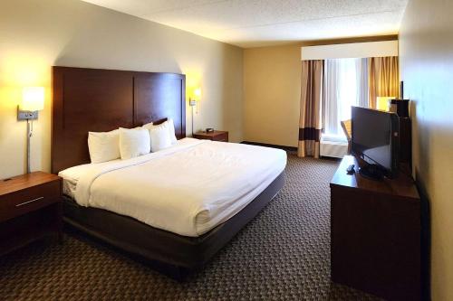 a hotel room with a bed and a flat screen tv at Comfort Inn & Suites Mount Pocono in Mount Pocono