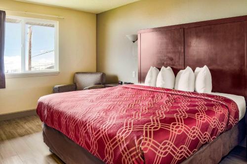 Econo Lodge في نيوبورت: غرفة فندقية بسرير كبير وكرسي