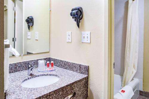 y baño con lavabo y espejo. en Econo Lodge, en Newport