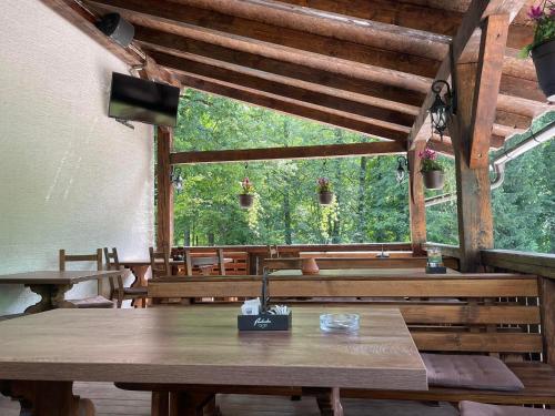 une salle à manger avec une table et une grande fenêtre dans l'établissement Hostel in picerija Špajza, à Mojstrana