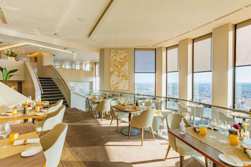 un restaurant avec des tables, des chaises et des fenêtres dans l'établissement Radisson Blu Hotel, Lyon, à Lyon