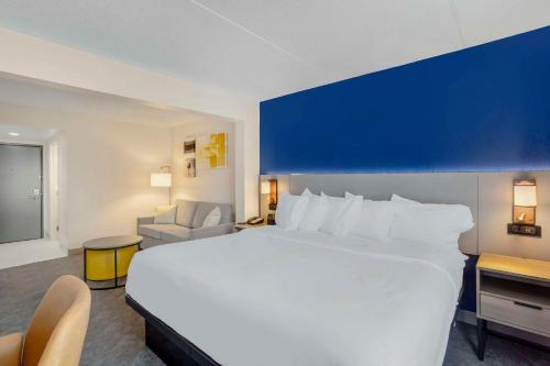 a hotel room with a large white bed and a chair at Comfort Inn & Suites Voorhees-Mt Laurel in Voorhees