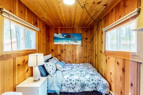 ein Schlafzimmer mit einem Bett in einer Holzhütte in der Unterkunft Loon Lake Retreat in Loon Lake