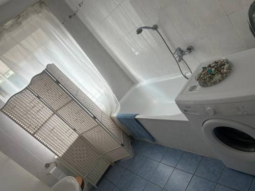 2 Zimmer Wohnung 1min Messe Köln في كولونيا: حمام مع غسالة ملابس بجانب مرحاض