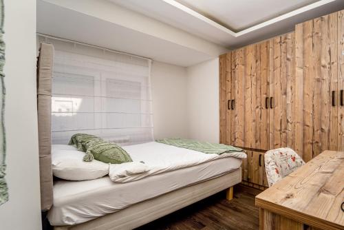 a small bedroom with a bed and a table at French House in Belgrade