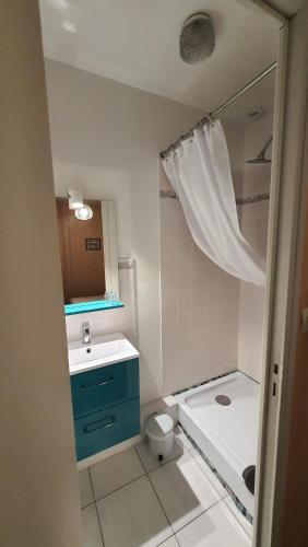 La salle de bains est pourvue d'une armoire bleue et d'un lavabo. dans l'établissement Le Relais du Chateau, à Oiron