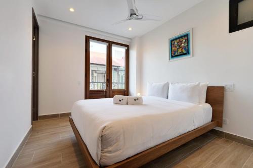 een slaapkamer met een groot wit bed en een raam bij Monochrome 2BR in Casco Viejo in Panama-Stad