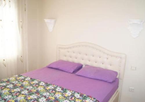 a white bed with purple pillows in a room at Didim Yazlik Ev 1 in Didim