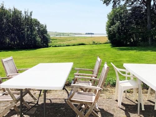 a group of white tables and chairs in a field at 11 person holiday home in Bedsted Thy in Bedsted Thy