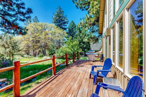 a deck with two chairs and a grill on a house at Marsh Hawk Cabin in Klamath Falls