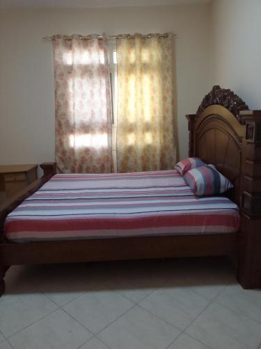 a bed in a room with a window at شقه غرفتين مفروشه in Sharjah