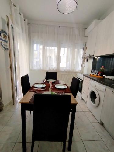 a kitchen with a table and chairs and a kitchen with a washing machine at Antonia's cozy apartment in Agia Triada