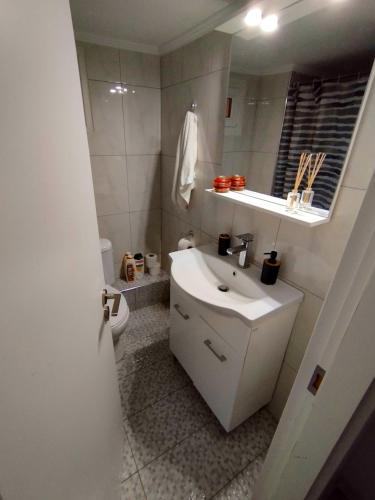 a white bathroom with a sink and a toilet at Antonia's cozy apartment in Agia Triada