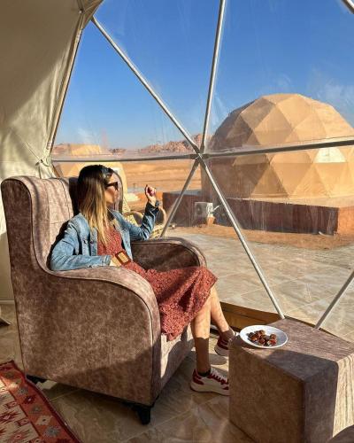 a woman sitting in a chair in a tent at Wadi Rum Aviva camp in Wadi Rum