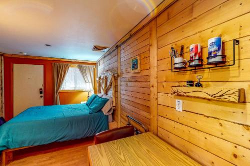 een slaapkamer met een bed en een houten muur bij Cedaredge Lodge, Cabin 3 in Cedaredge