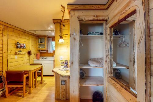 a kitchen with wooden walls and a table in a room at Cedaredge Lodge, Cabin 3 in Cedaredge