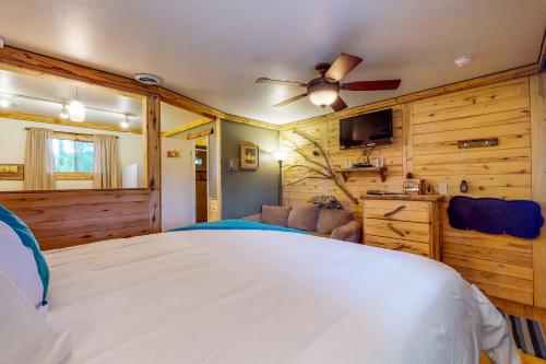 a bedroom with a bed and a ceiling fan at Cedaredge Lodge, Cabin 7 in Cedaredge