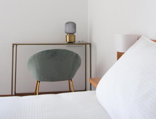 a bedroom with a green chair next to a bed at HOTEL BOUTIQUE VILAVELLA in O Grove