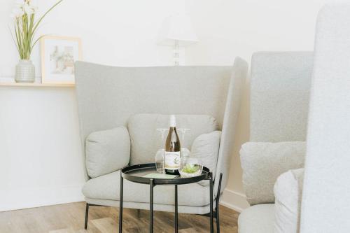 a bottle of wine on a table next to a chair at Naramata Courtyard Suites in Naramata