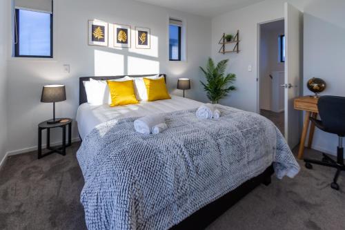 a bedroom with a bed with yellow pillows and a desk at 3 bedroom 2 bath Central City in Christchurch