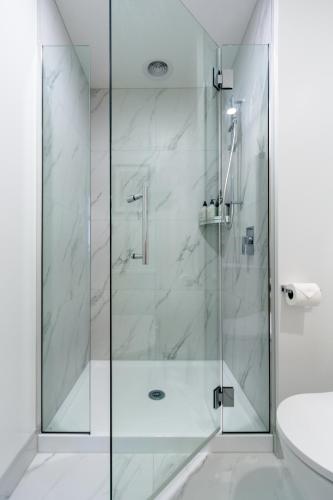 a shower with a glass door in a bathroom at 3 bedroom 2 bath Central City in Christchurch