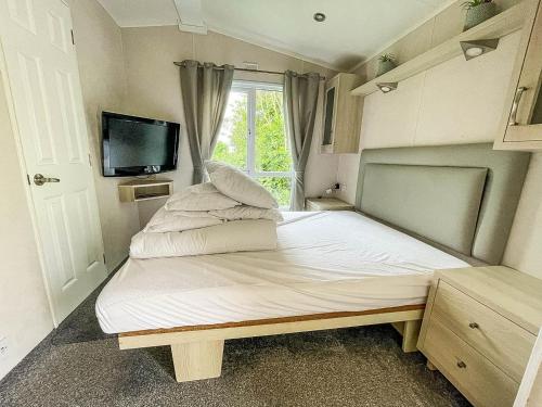 a small bed in a small room with a window at Lovely Wheelchair Friendly Caravan At Skipsea Sands In Yorkshire Ref 41167wf in Barmston