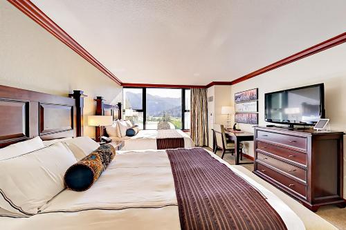 a hotel room with a large bed and a flat screen tv at 556 Everline in Olympic Valley