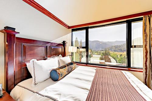 um quarto com uma cama grande e uma janela grande em 556 Everline em Olympic Valley