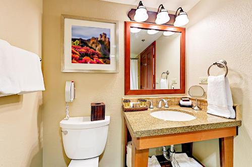 uma casa de banho com um WC, um lavatório e um espelho. em 556 Everline em Olympic Valley