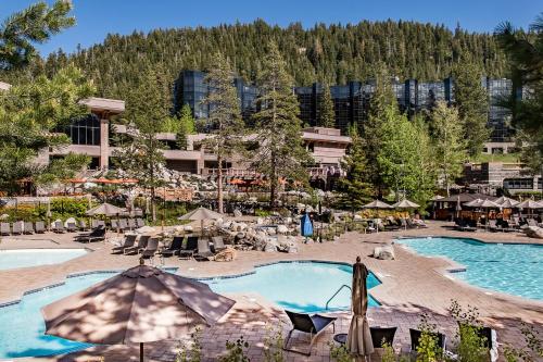 a resort with a pool with umbrellas and a mountain at 556 Everline in Olympic Valley