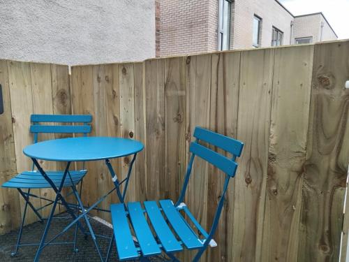 two blue chairs and a table in front of a fence at No.5 in Derry Londonderry