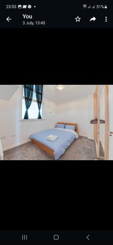 um quarto com uma cama num quarto com uma janela em Princess Street Apartment em Manchester