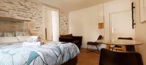 une chambre avec un lit, une table et des chaises dans l'établissement La Douce Angevine - La Perruche - Proche centre, à Angers
