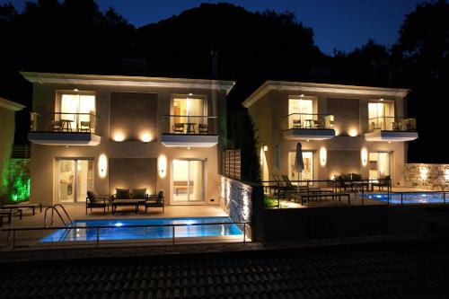 帕爾加的住宿－Elais Luxury Villas，一座白色的大建筑,晚上设有游泳池