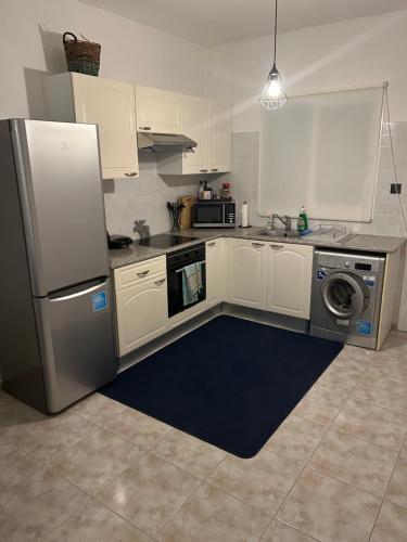 eine Küche mit einem Kühlschrank aus Edelstahl und einem Geschirrspüler in der Unterkunft Cozy Paphos Apartment in Paphos City