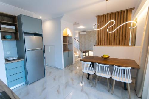 a kitchen with a wooden table and white chairs at Elais Luxury Villas in Parga