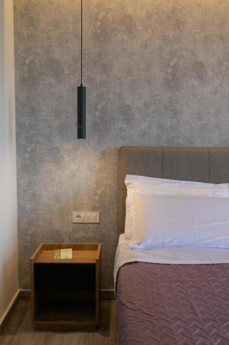 a bedroom with a bed and a nightstand with a lamp at Elais Luxury Villas in Parga