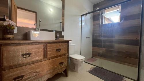 een badkamer met een douche, een toilet en een wastafel bij Pouso Flor da serra in Tiradentes