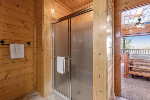 a bathroom with a shower in a wooden wall at Soaring High in Pigeon Forge