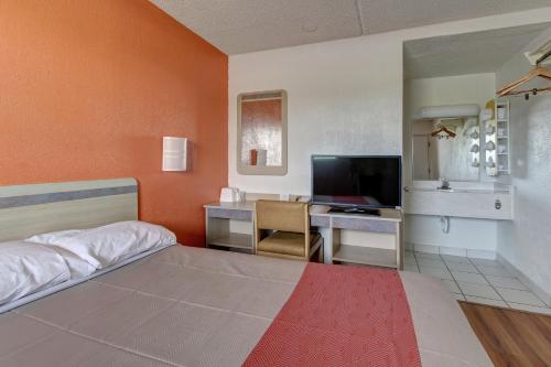 a bedroom with a bed and a desk with a television at Motel 6-North Ridgeville, OH - Cleveland Intl Airport - N Ridgeville in North Ridgeville
