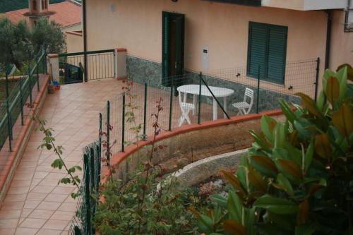 - un balcon d'une maison avec une table et une clôture dans l'établissement Casa Giulia a Belmonte Calabro, à Belmonte Calabro