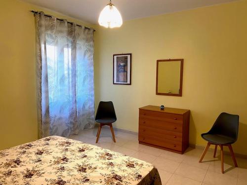 - une chambre avec un lit, deux chaises et une commode dans l'établissement Casa Giulia a Belmonte Calabro, à Belmonte Calabro