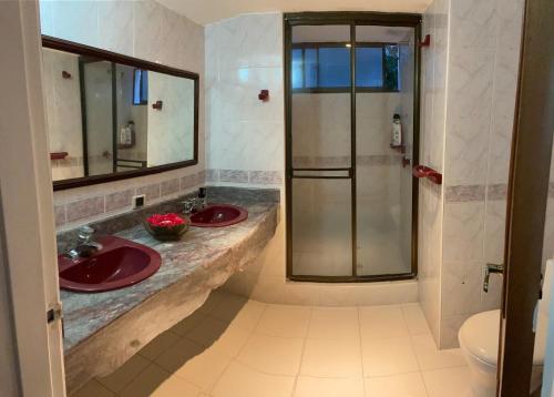 a bathroom with two sinks and a shower at El Peñón, Girardot-Colombia in Girardot