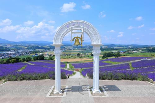 a gazebo in the middle of a field of purple flowers at 别墅之家オーナーChangeAorB in Kami-furano