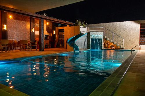 a swimming pool at night with a water slide at Mar e Lar in Maragogi