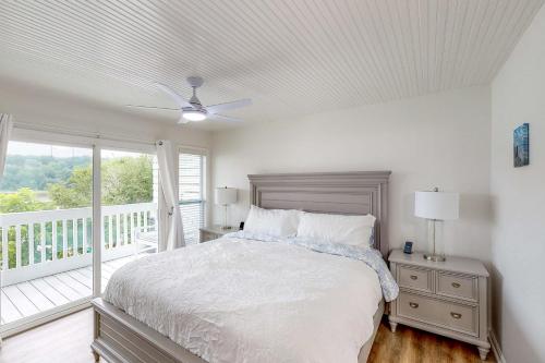 Habitación blanca con cama y balcón. en Edgewater Way en Onalaska
