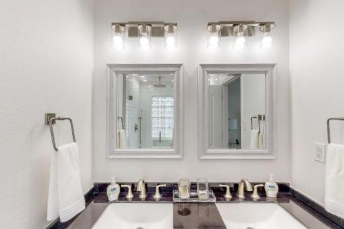 a bathroom with two sinks and two mirrors at Edgewater Way in Onalaska